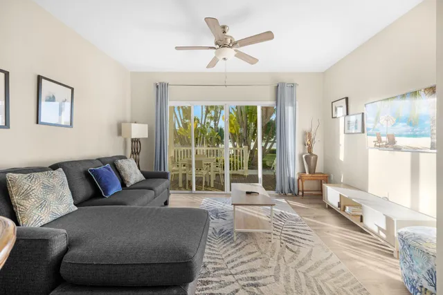 a living room with furniture and a large window with garden view