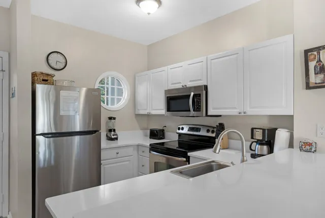 a kitchen with stainless steel appliances granite countertop a refrigerator a stove a sink and a microwave