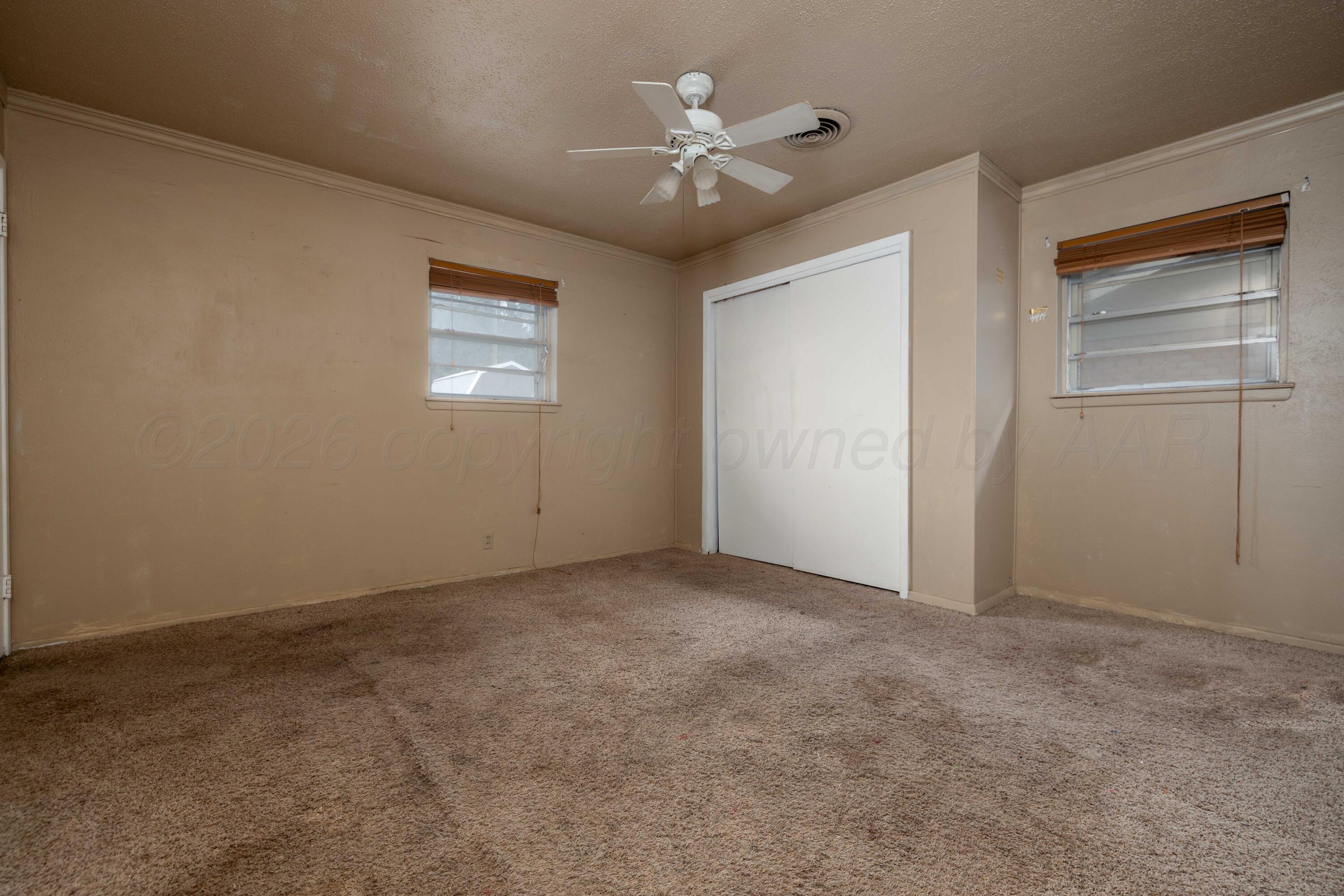 712 West Oak Street Dimmitt, TX 79027 - Photo 13 of 19 an empty room with windows and ceiling fan