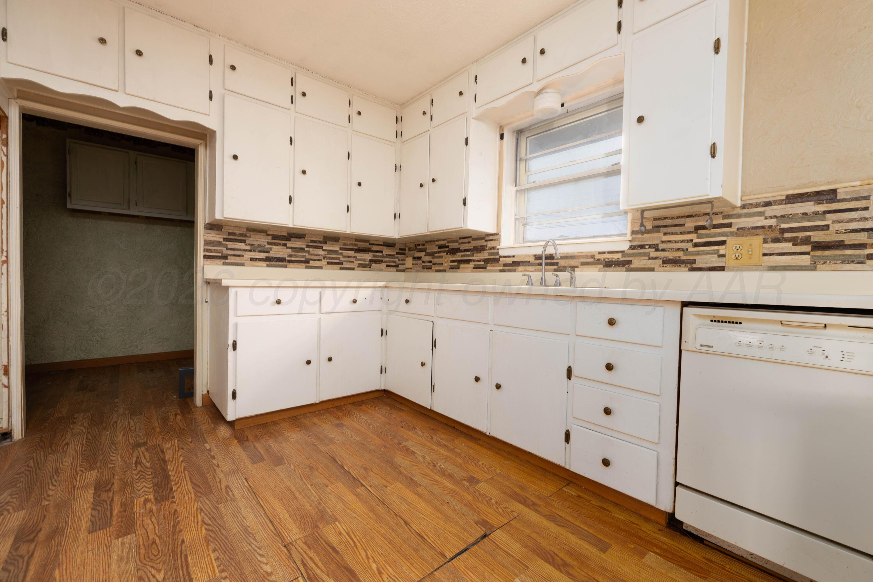 712 West Oak Street Dimmitt, TX 79027 - Photo 8 of 19 a kitchen with granite countertop white cabinets and white appliances