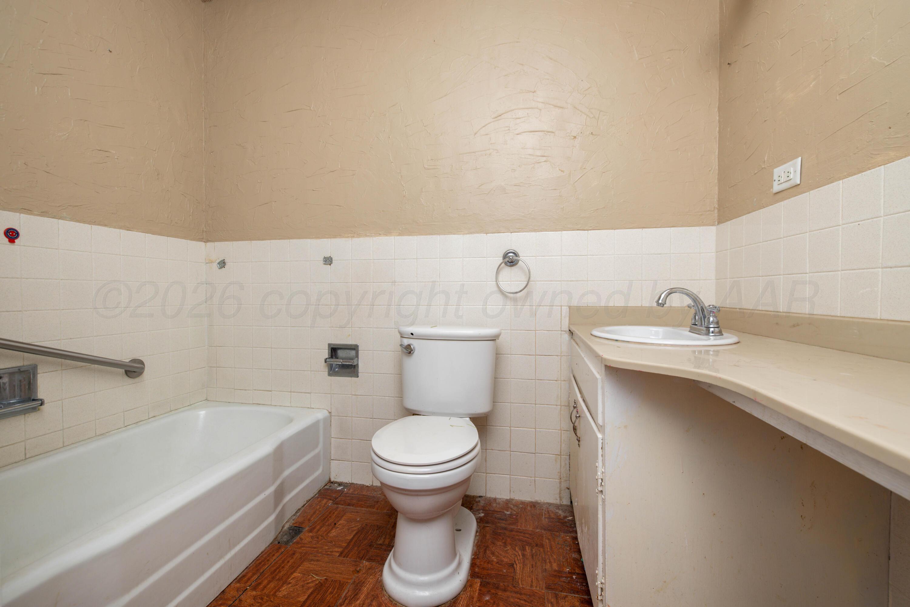 712 West Oak Street Dimmitt, TX 79027 - Photo 9 of 19 a bathroom with a sink a toilet and bathtub