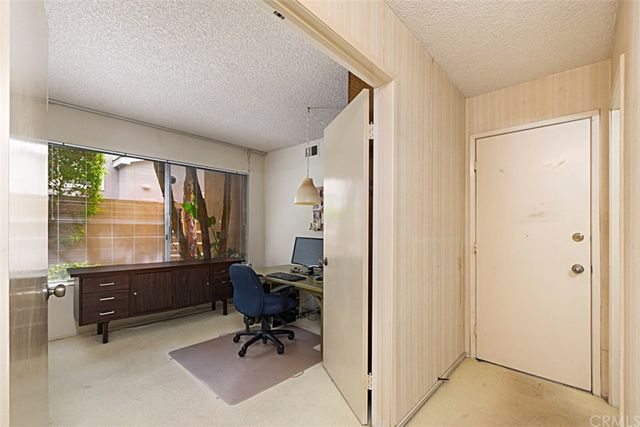 a spacious bedroom with a bed a table and window