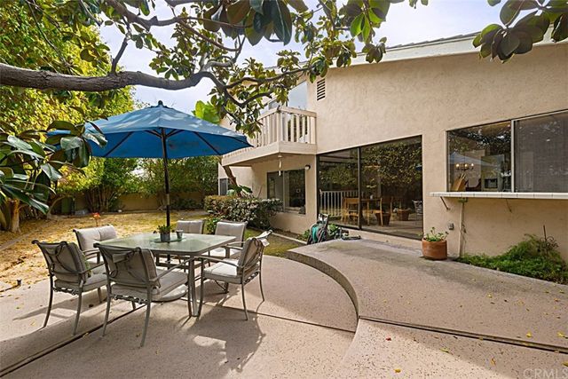 a view of a road with plants and large trees