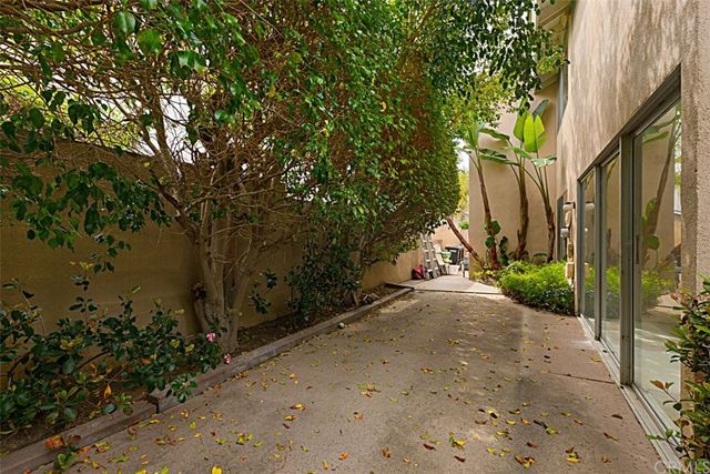a backyard of a house with table and chairs under an umbrella