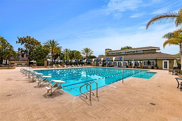 a view of swimming pool with outdoor seating and house in the background