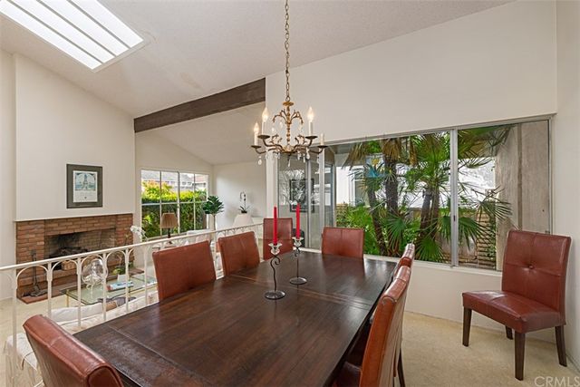 a view of a dining room with furniture a chandelier and large windows