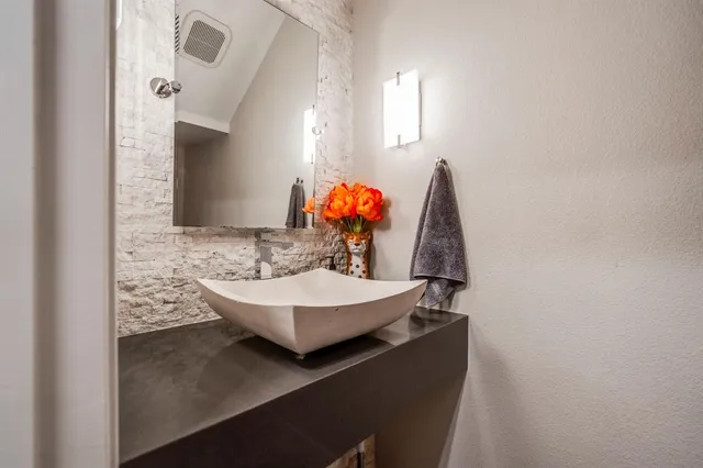 a view of a patio with couches chairs potted plants and a dining table under a large window