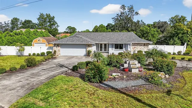 a front view of a house with a yard and potted plants