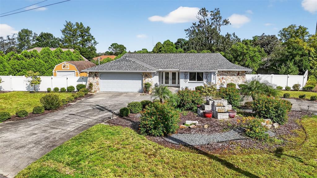 3025 Whitewood Avenue Spring Hill, FL 34609 - Photo 1 of 53 a front view of a house with a yard and potted plants