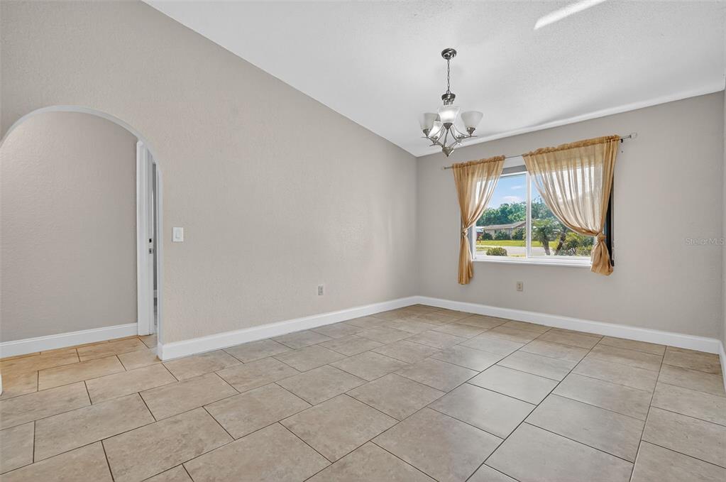 3025 Whitewood Avenue Spring Hill, FL 34609 - Photo 26 of 53 an empty room with windows and chandelier fan
