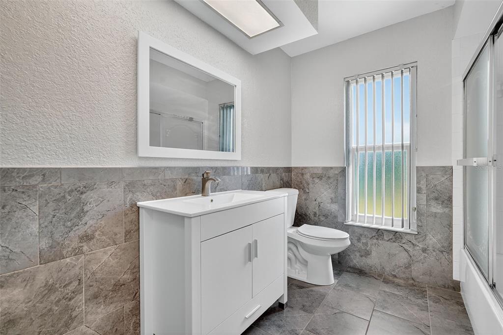 3025 Whitewood Avenue Spring Hill, FL 34609 - Photo 30 of 53 a bathroom with a toilet sink and mirror