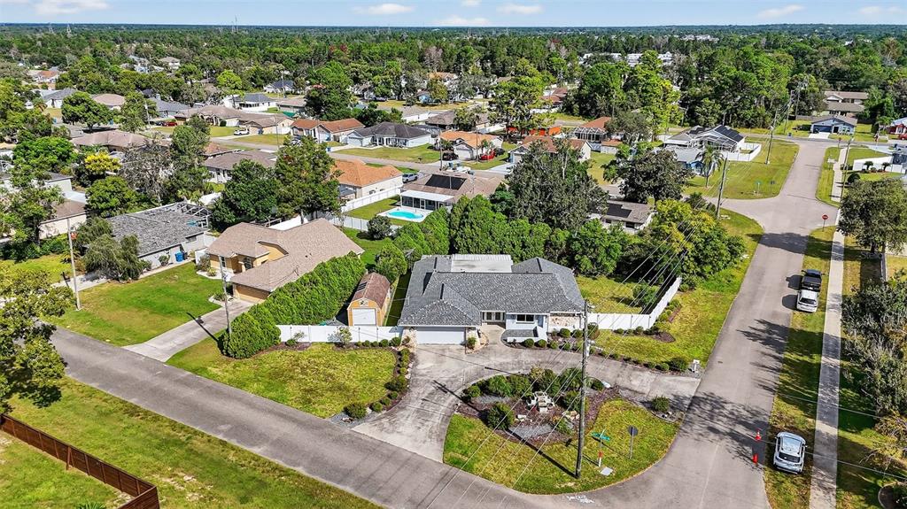 3025 Whitewood Avenue Spring Hill, FL 34609 - Photo 3 of 53 an aerial view of a house with a garden and lake view