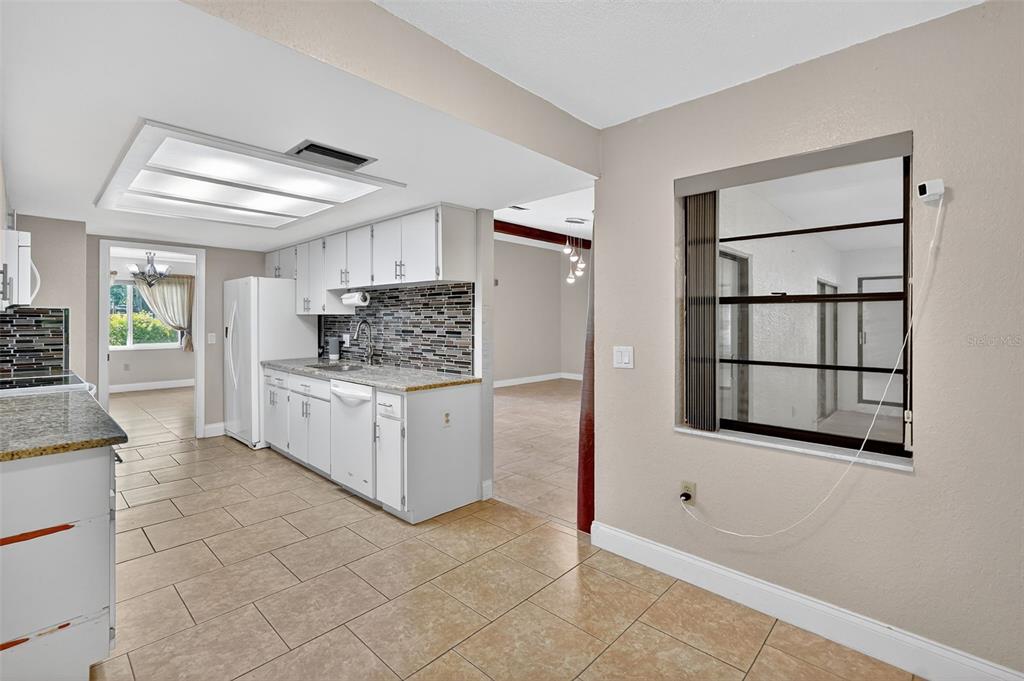 3025 Whitewood Avenue Spring Hill, FL 34609 - Photo 36 of 53 a kitchen with a stove and white cabinets