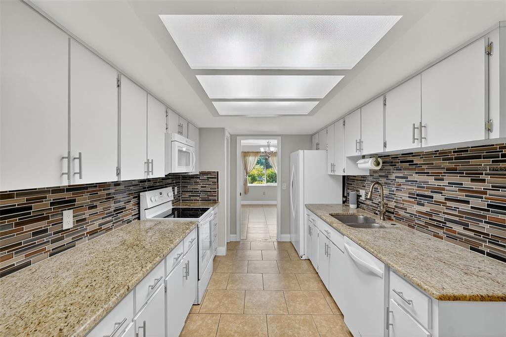 3025 Whitewood Avenue Spring Hill, FL 34609 - Photo 37 of 53 a kitchen with stainless steel appliances granite countertop a stove a sink and a refrigerator