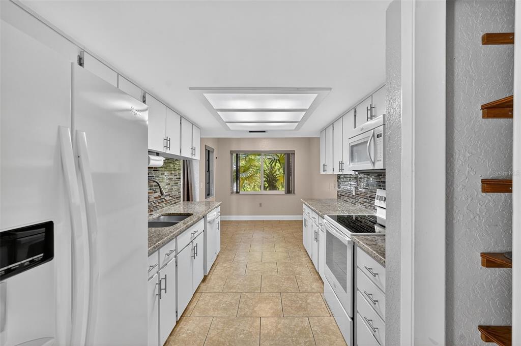 3025 Whitewood Avenue Spring Hill, FL 34609 - Photo 40 of 53 a kitchen with granite countertop a refrigerator and a stove