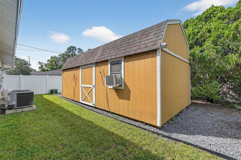 3025 Whitewood Avenue Spring Hill, FL 34609 - Photo 50 of 53 a backyard of a house with lawn chairs and wooden fence
