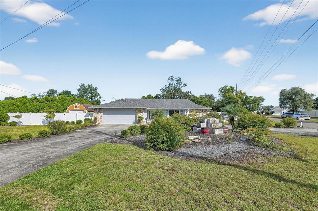 3025 Whitewood Avenue Spring Hill, FL 34609 - Photo 9 of 53 a view of a house with a backyard and a garden