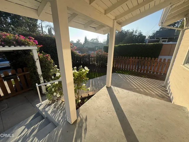 a balcony with view of water fountain and wooden floor
