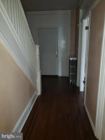 a view of a hallway with wooden floor and stairs