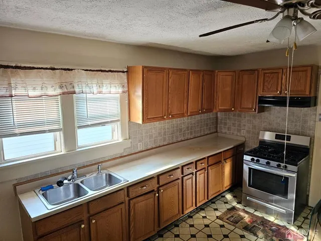 a kitchen with stainless steel appliances a sink stove and cabinets