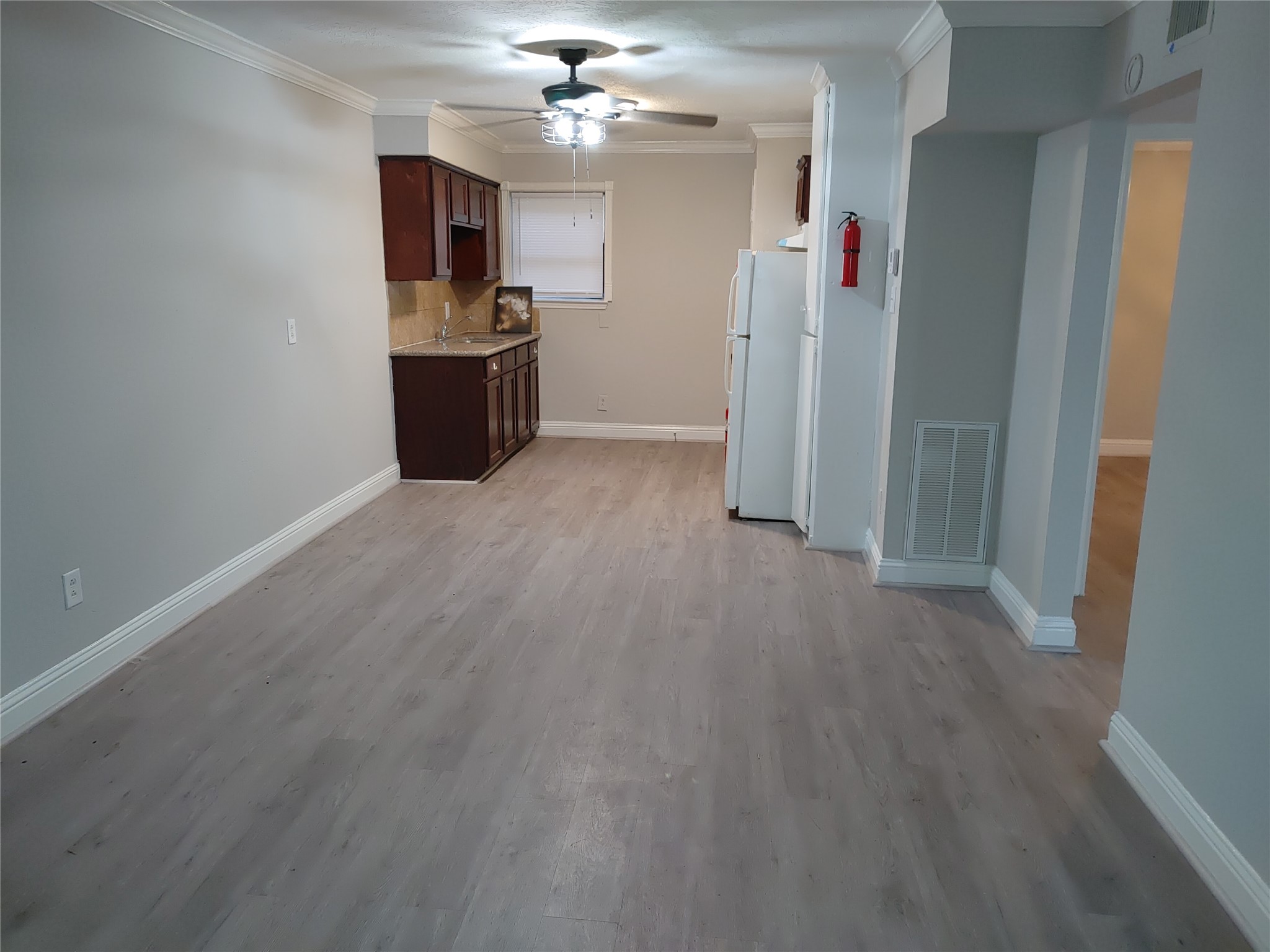 wooden floor in an empty room with a kitchen