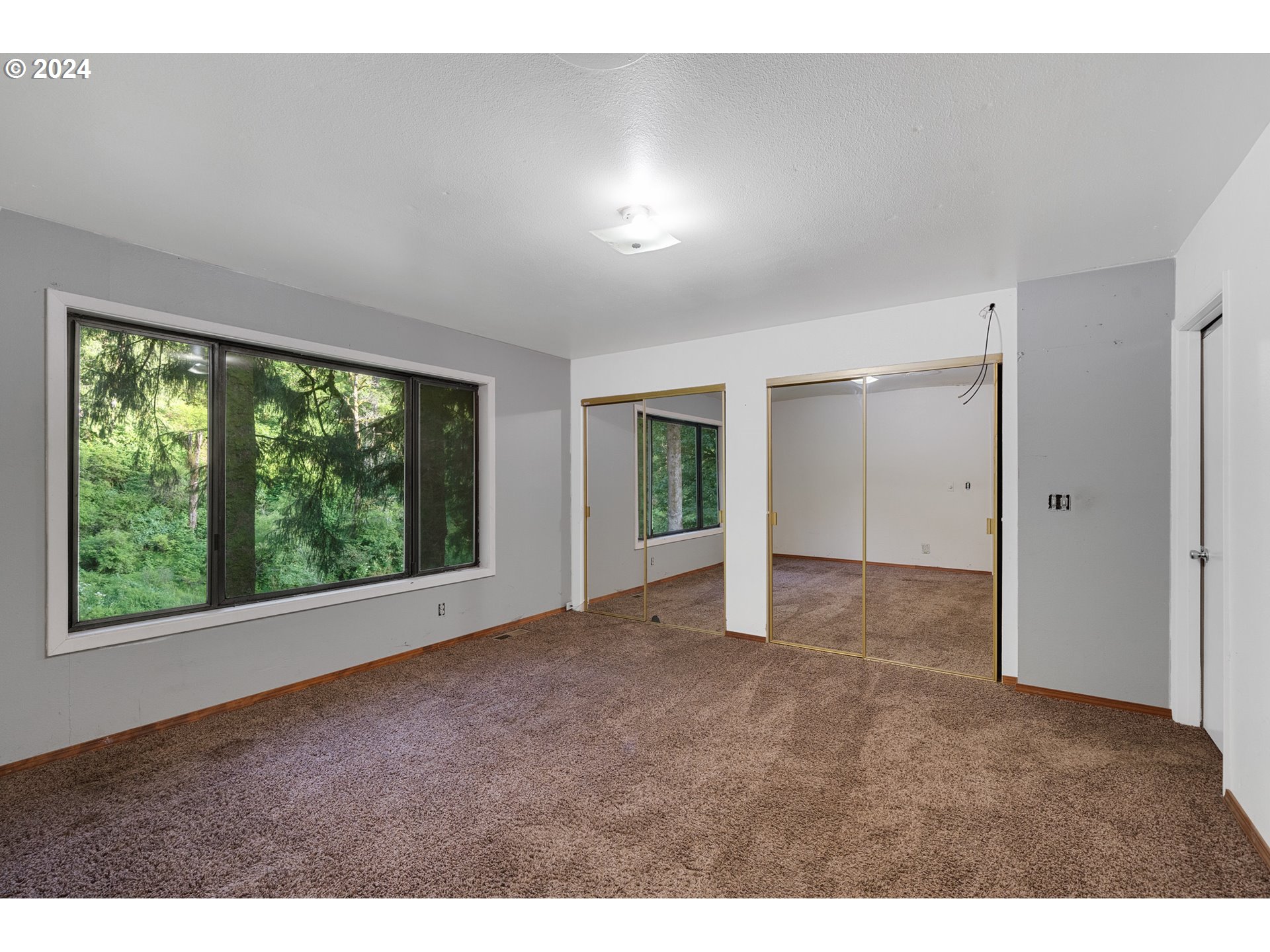 15555 Trask River Road Tillamook, OR 97141 - Photo 15 of 30 a view of an empty room with wooden floor and a window