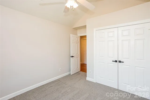 an empty room with a chandelier fan