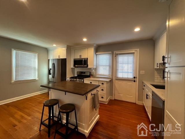 89 Leo Street Edison, NJ 08817 - Photo 5 of 31 a kitchen with stainless steel appliances kitchen island granite countertop a stove top oven a sink a refrigerator and white cabinets with wooden floor