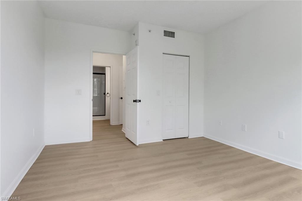 1190 Reserve Way, Unit 206 Naples, FL 34105 - Photo 18 of 35 a view of an empty room with wooden floor