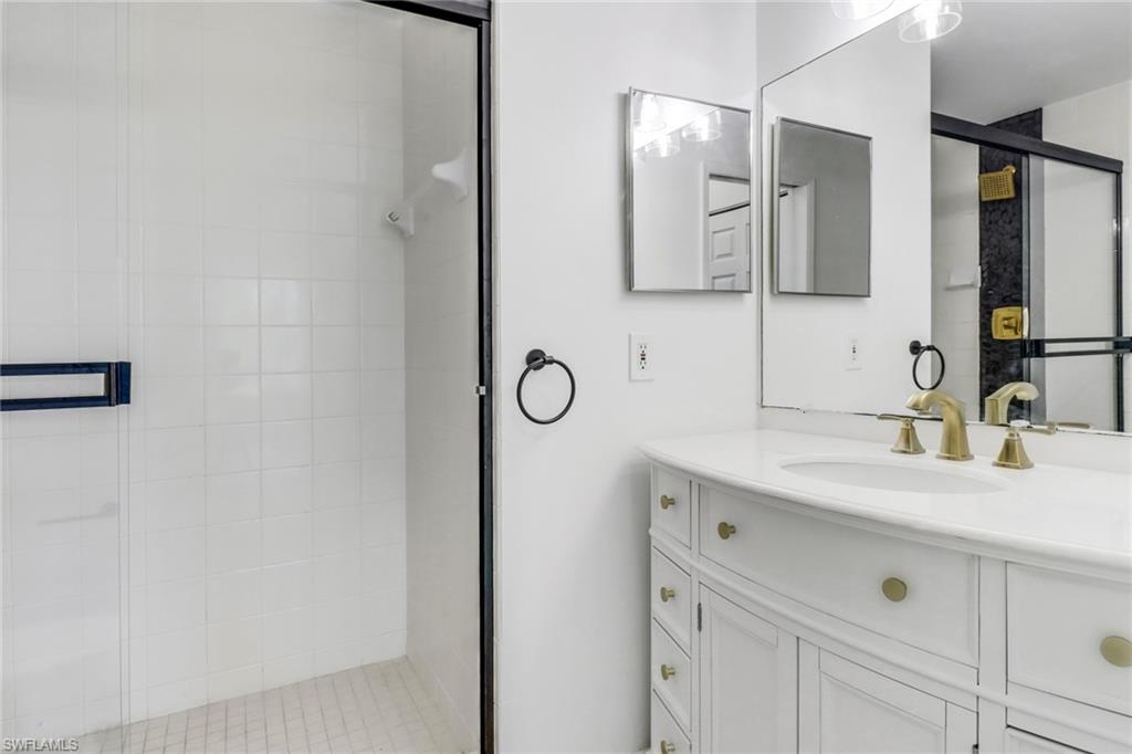 1190 Reserve Way, Unit 206 Naples, FL 34105 - Photo 19 of 35 a bathroom with a sink and a mirror