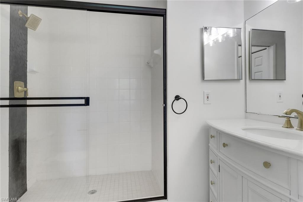1190 Reserve Way, Unit 206 Naples, FL 34105 - Photo 20 of 35 a bathroom with a double vanity sink and a mirror