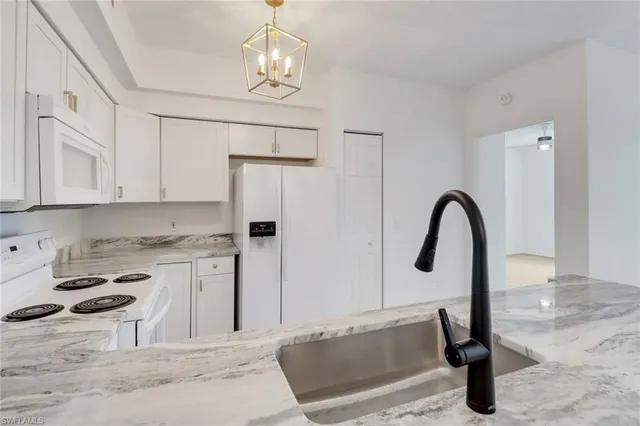 a kitchen with kitchen island granite countertop a stove and a sink with granite countertops