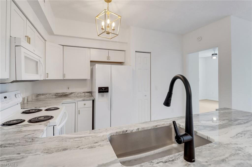 1190 Reserve Way, Unit 206 Naples, FL 34105 - Photo 3 of 35 a kitchen with kitchen island granite countertop a stove and a sink with granite countertops