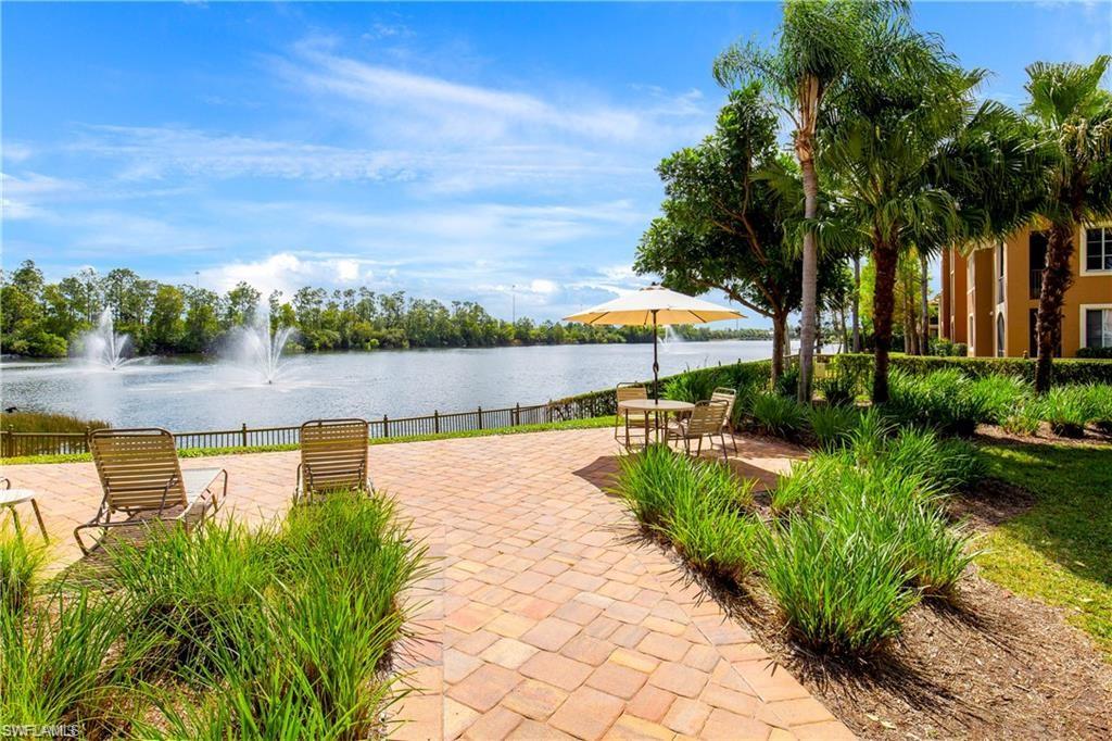 1190 Reserve Way, Unit 206 Naples, FL 34105 - Photo 33 of 35 a view of swimming pool with seating area and trees in the background