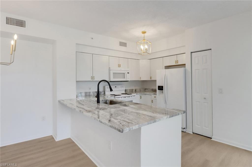 1190 Reserve Way, Unit 206 Naples, FL 34105 - Photo 4 of 35 a kitchen with stainless steel appliances granite countertop a sink a refrigerator and a granite counter tops