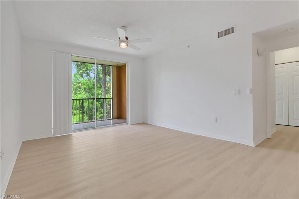 1190 Reserve Way, Unit 206 Naples, FL 34105 - Photo 10 of 35 a view of an empty room with wooden floor and a window