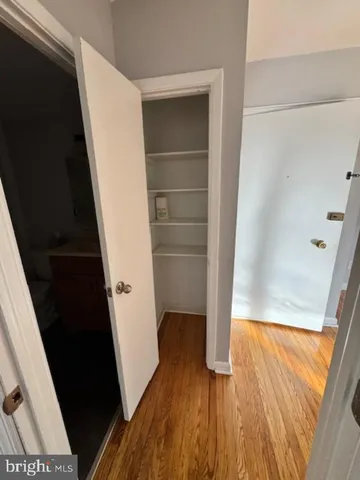 a view of walk in closet with wooden floor