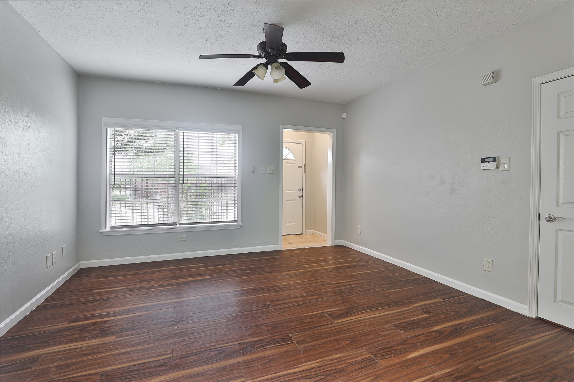 5009 Polk Street Houston, TX 77023 - Photo 4 of 16 a view of an empty room with wooden floor and a window