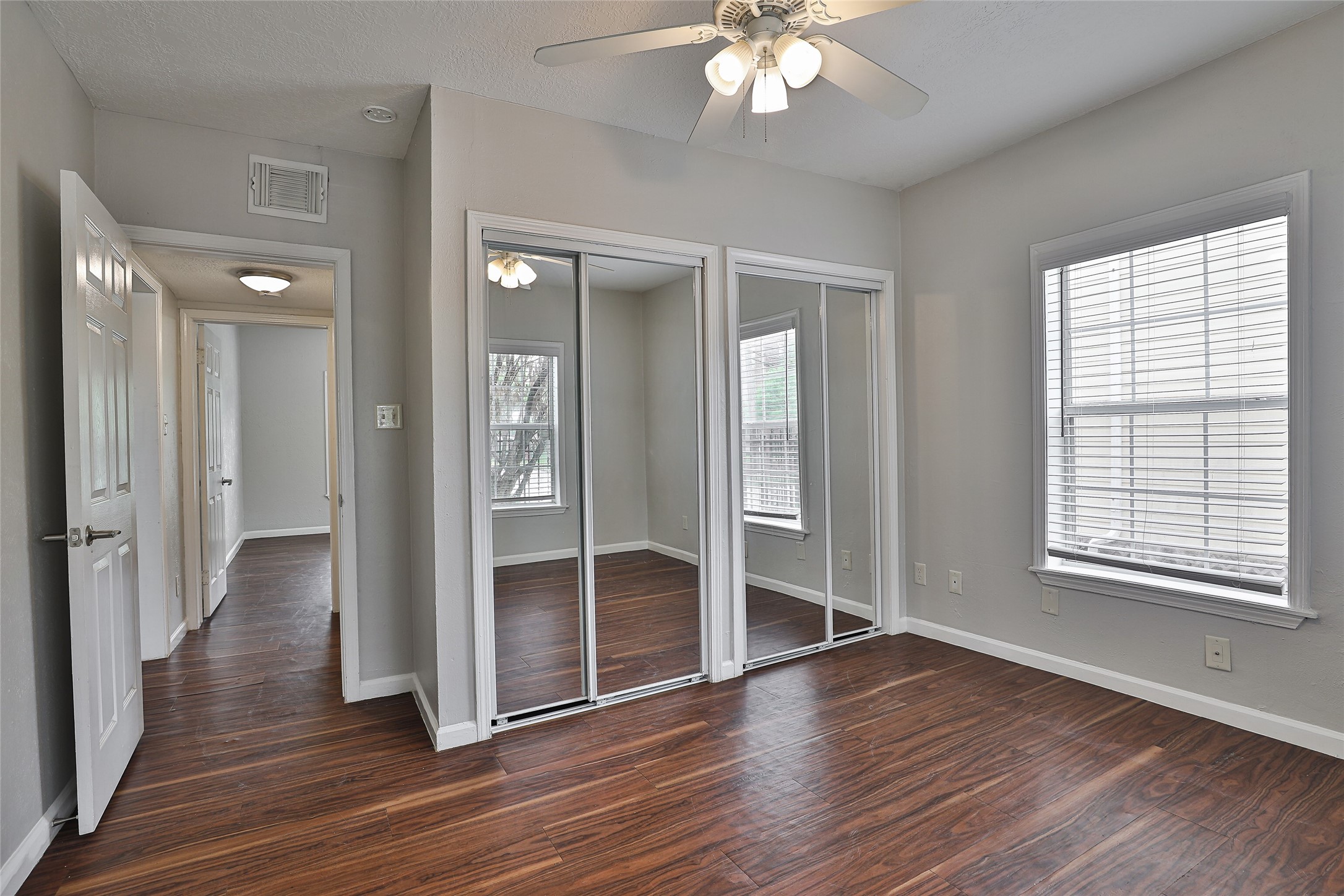 5009 Polk Street Houston, TX 77023 - Photo 8 of 16 an empty room with wooden floor fan and windows