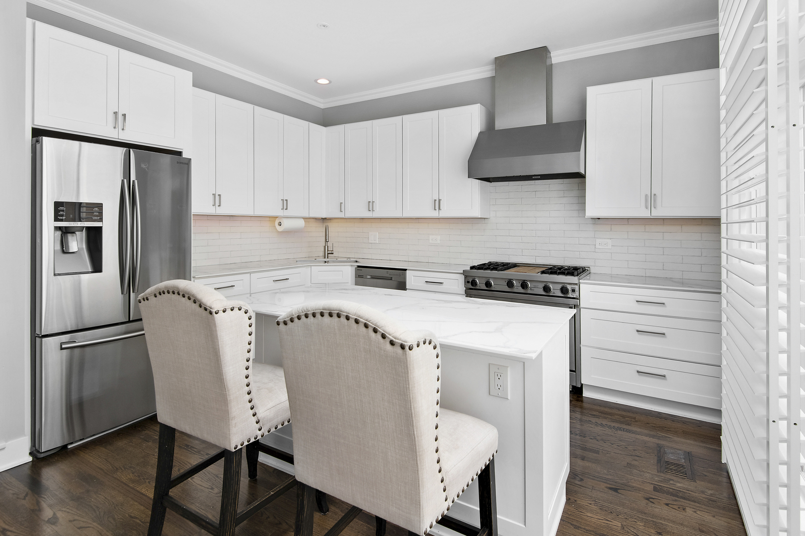 520 North Peoria Street Chicago, IL 60642 - Photo 4 of 20 a kitchen with stainless steel appliances white cabinets and wooden floor