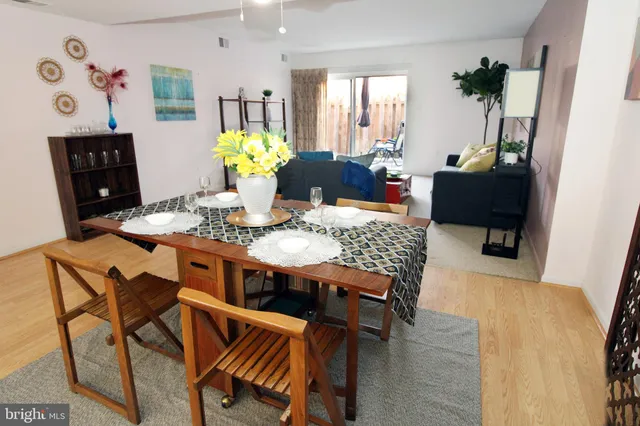 a living room with furniture a dining table and a potted plant