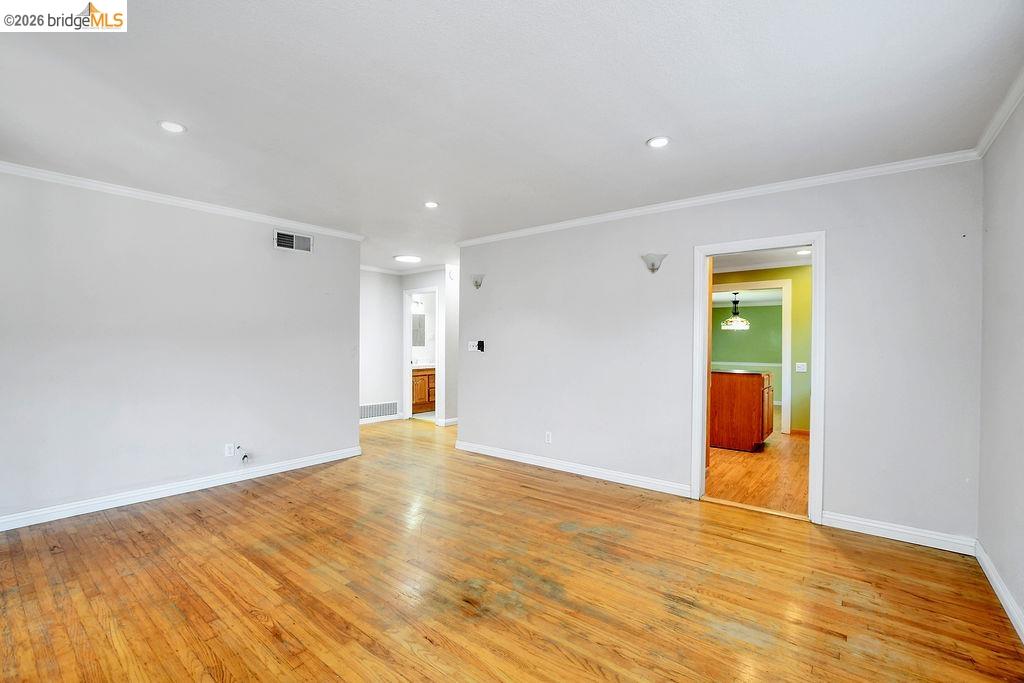 805 Calero Street Milpitas, CA 95035 - Photo 9 of 23 Spacious room featuring wood-finish flooring, light grey walls, and white crown molding