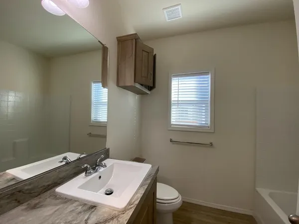 a bathroom with a sink toilet and mirror