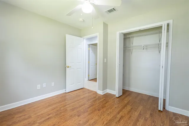 an empty room with wooden floor and closet