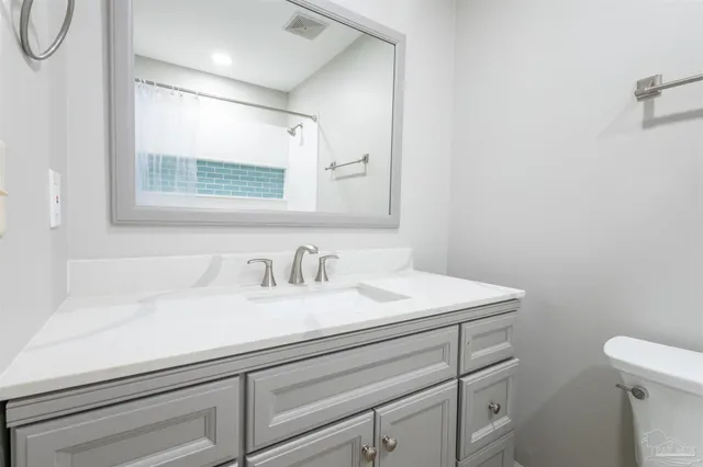 a bathroom with a sink a toilet and a mirror