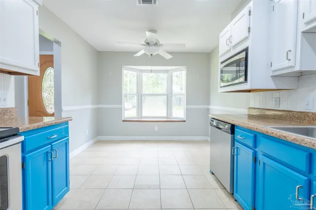 a kitchen with granite countertop a stove a sink and a cabinets