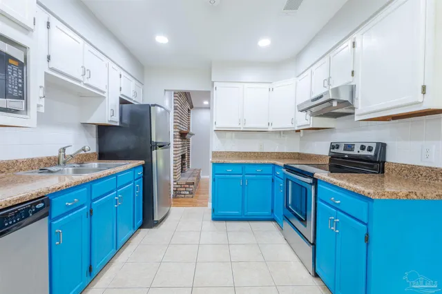 a kitchen with stainless steel appliances granite countertop a refrigerator and a stove top oven
