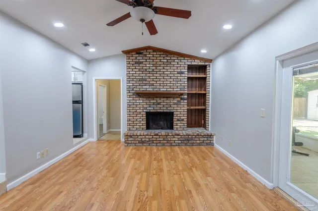 a view of an empty room with a fireplace and a window