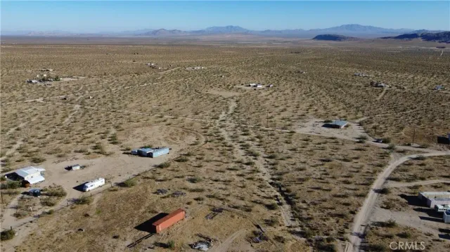 a view of a dry yard with mountains in the background