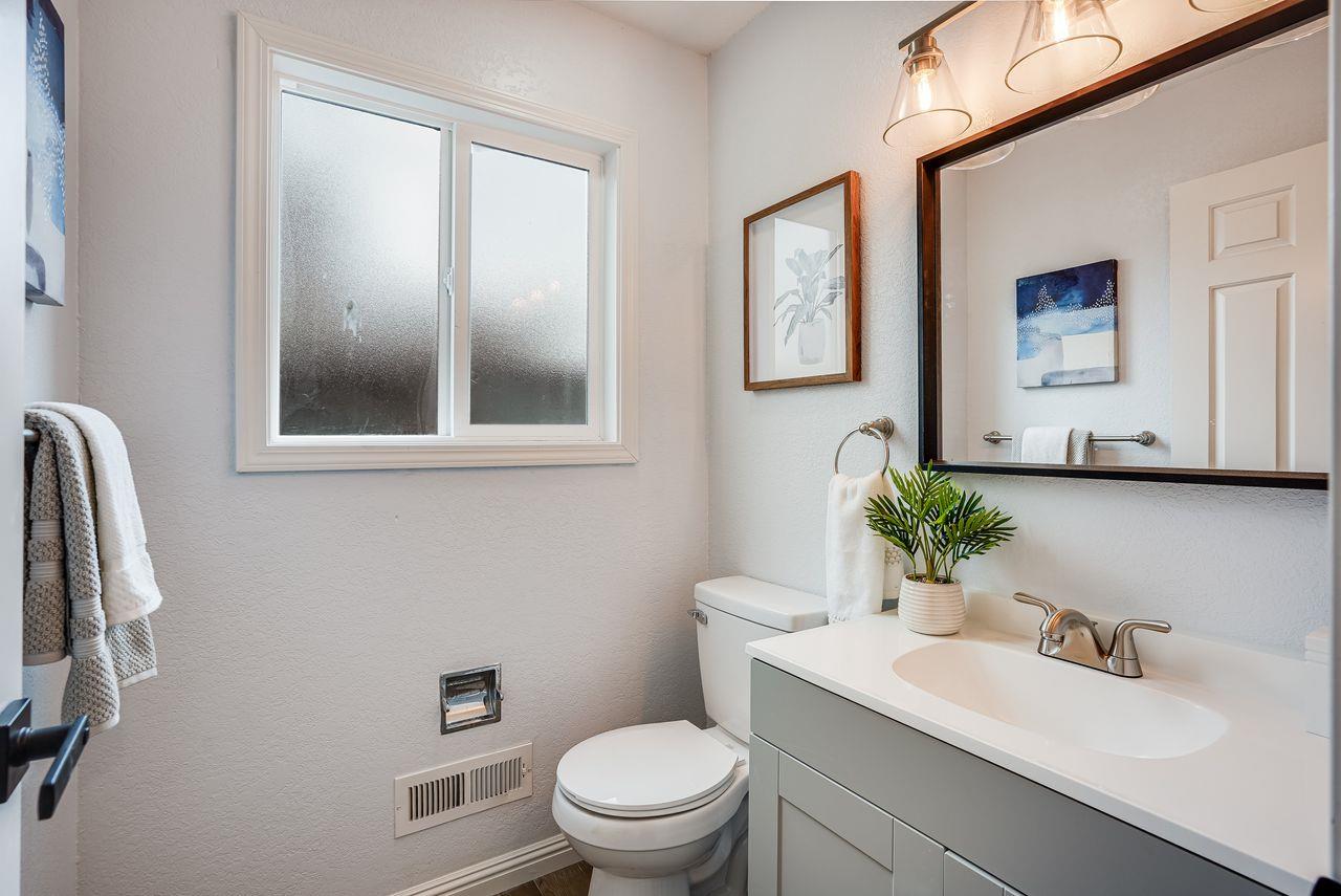 6586 Broadacres Drive San Jose, CA 95120 - Photo 23 of 37 a bathroom with a toilet a sink a mirror a vanity and window